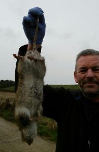 Picture of Terry Walker from TP Pest Control Services holding a rat that was caught by Max the Terrier.